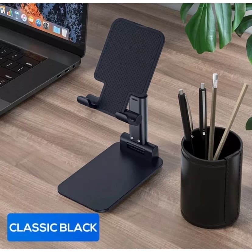 Suporte dobrável preto para tablet com superfície de borracha e rótulo 'CLASSIC BLACK', em fundo de madeira com porta-canetas