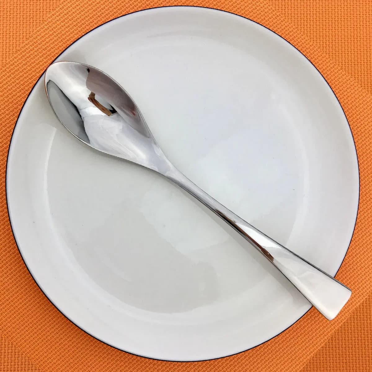 Colher de mesa luxo em aço inoxidável 304 com acabamento espelhado prata sobre prato branco