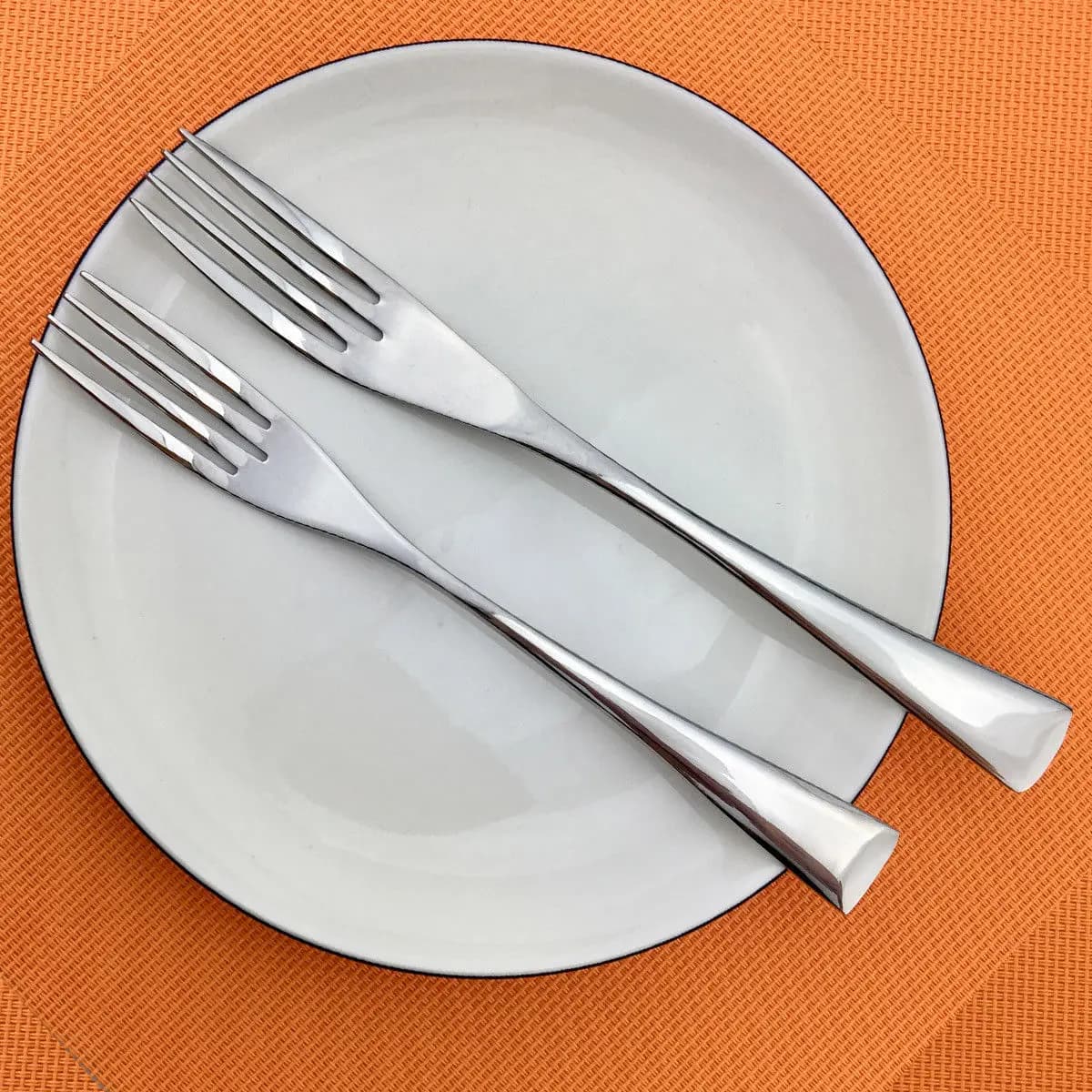 Duas garfos de mesa luxo em aço inoxidável 304 com acabamento espelhado prata sobre prato branco