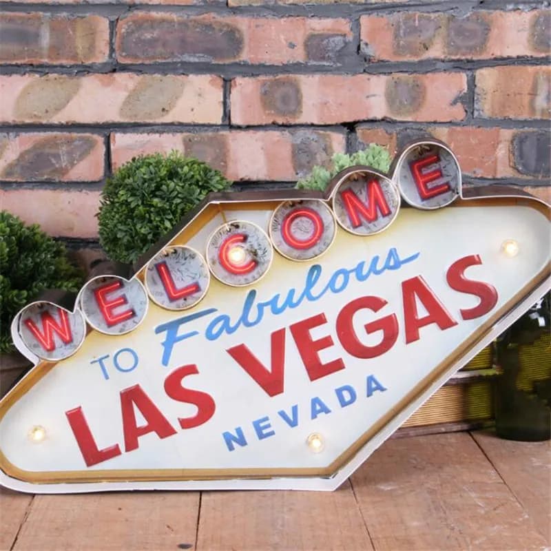 Sinal de néon vintage de Las Vegas com letras LED vermelhas e azuis, fundo branco, texto 'WELCOME TO FABULOUS LAS VEGAS NEVADA'.