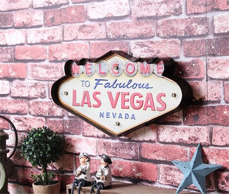 Placa decorativa vintage Las Vegas LED em metal branco pendurada em parede de tijolos vermelhos