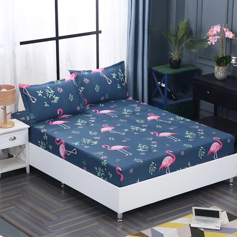 Fronha e capa de colchão com estampa de flamingos rosa e folhas verdes sobre cama azul