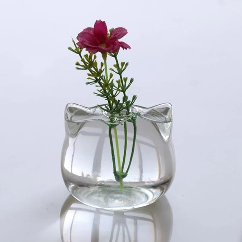 Vaso de vidro em forma de gato com flor rosa