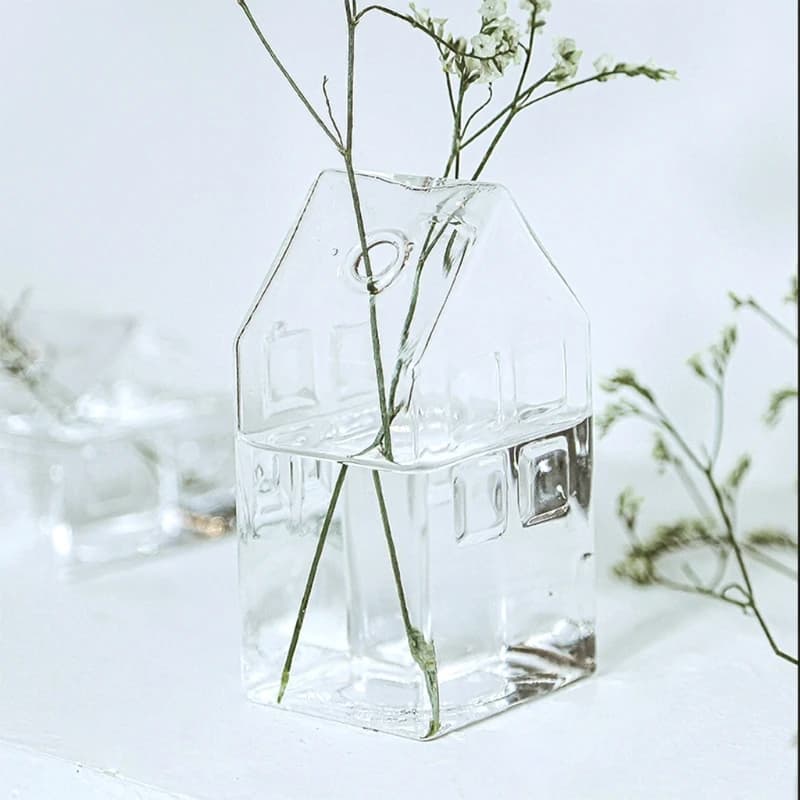 Vaso decorativo de vidro transparente formato casa com flores secas delicadas