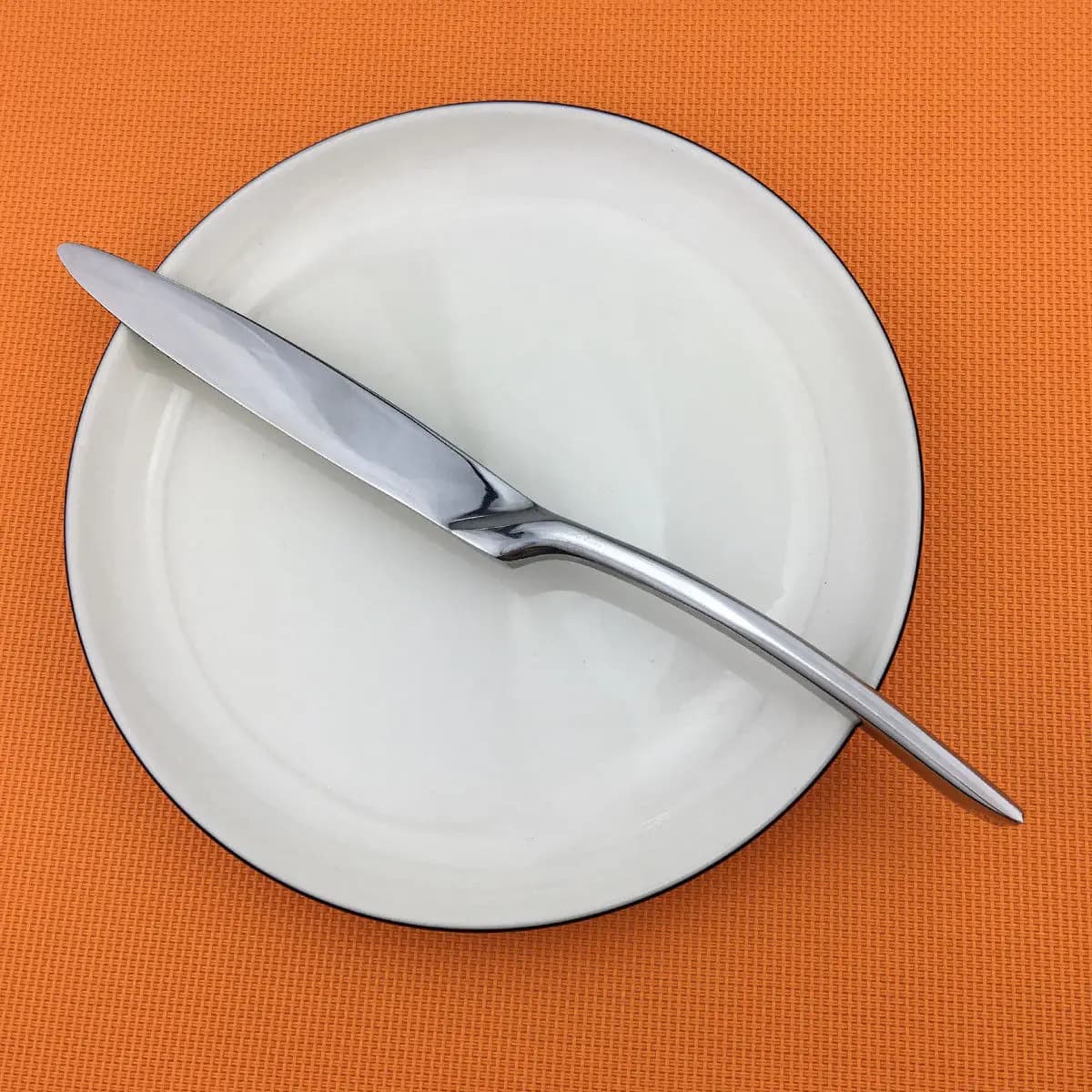 Faca de mesa luxo em aço inoxidável 304 com acabamento espelhado prata sobre prato branco