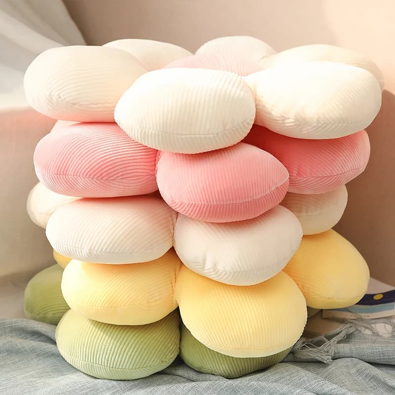 Almofadas florais empilhadas em tecido de veludo cotelê nas cores rosa, amarelo, verde e creme