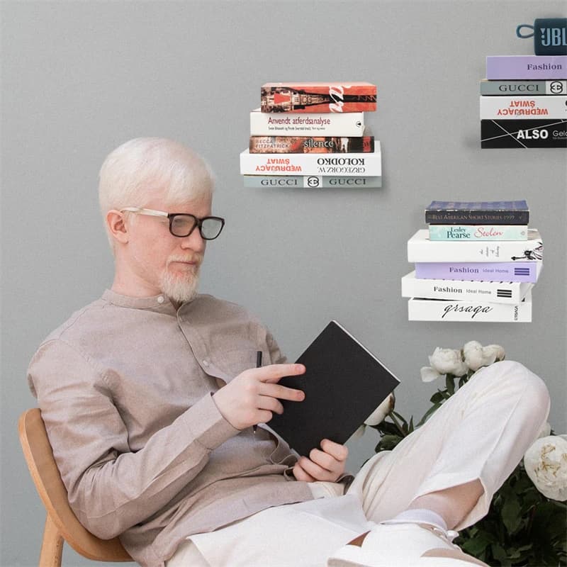 Suporte de parede invisível preto para prateleira flutuante usado para organizar livros em parede cinza