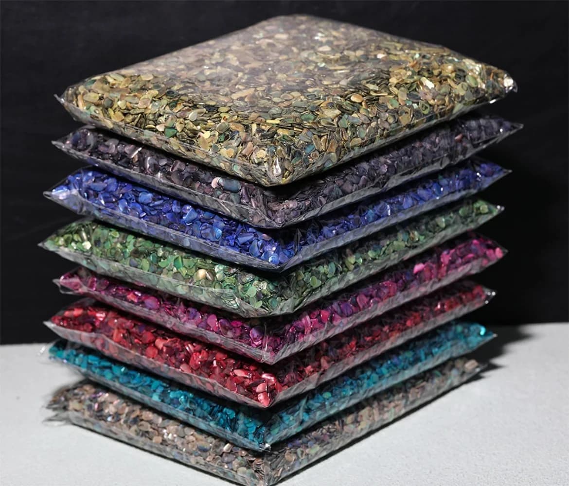 Pacotes de fragmentos de concha natural coloridos para nail art empilhados em fundo cinza