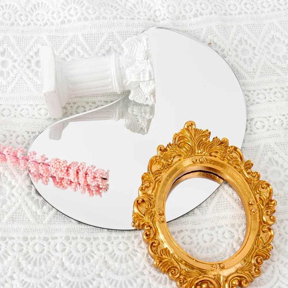Espelho decorativo Jácotei irregular acrílico transparente sobre tecido branco com moldura dourada e decoração rosa