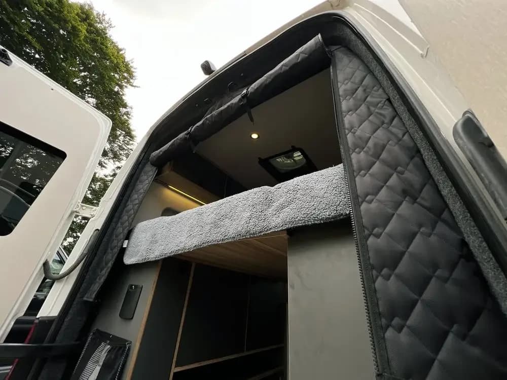 Cortina isolante preta térmica para porta traseira de van instalada, com acabamento acolchoado e zíper