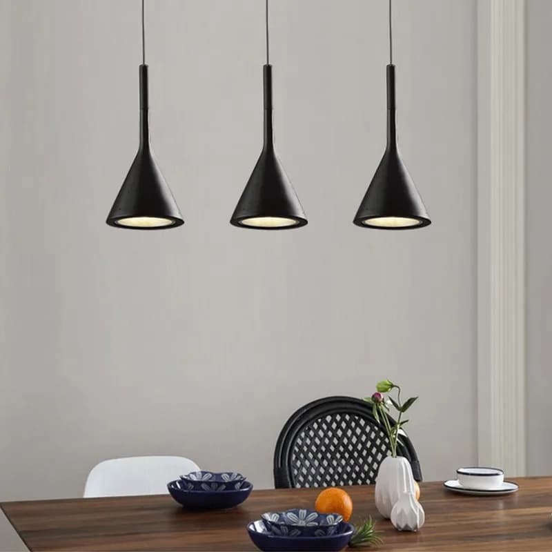 Três luminárias pendentes pretas foscas com luz LED direcionada sobre mesa de jantar moderna