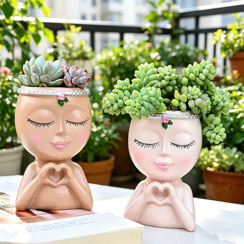 Vaso de plantas suculentas em forma de boneca rosa com flores verdes