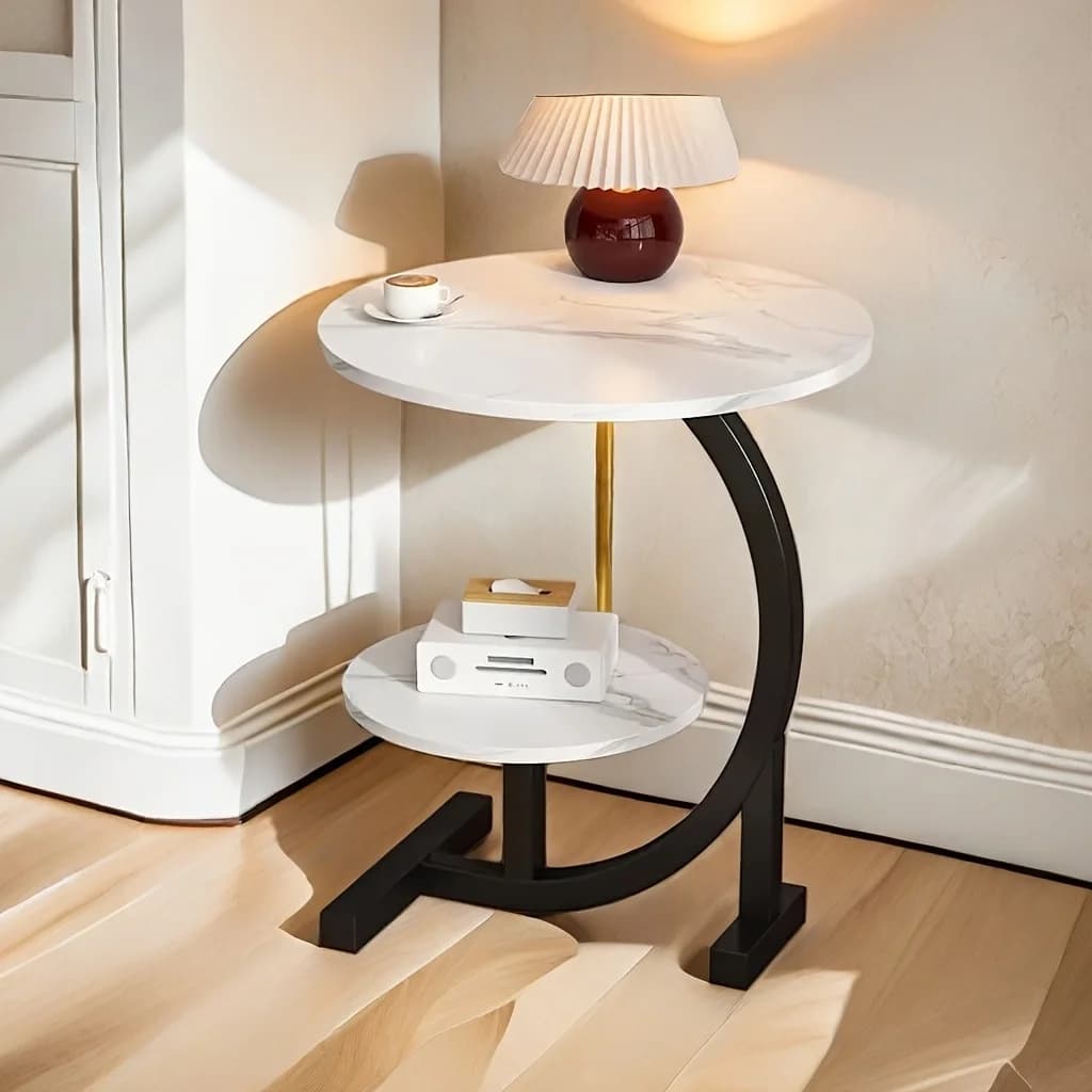 Mesa lateral redonda de mármore branco com base preta, ideal para sala de estar.