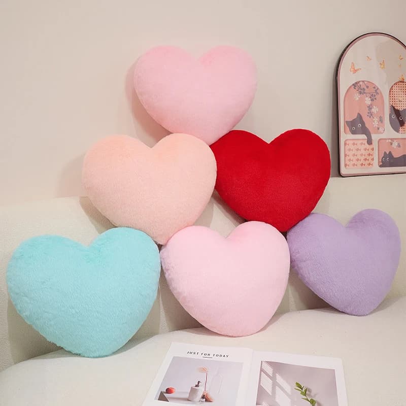 Conjunto de almofadas peludas em formato de coração com cores variadas em sofá branco