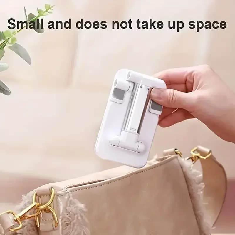 Suporte para telefone branco dobrável compacto sendo guardado em bolsa pequena