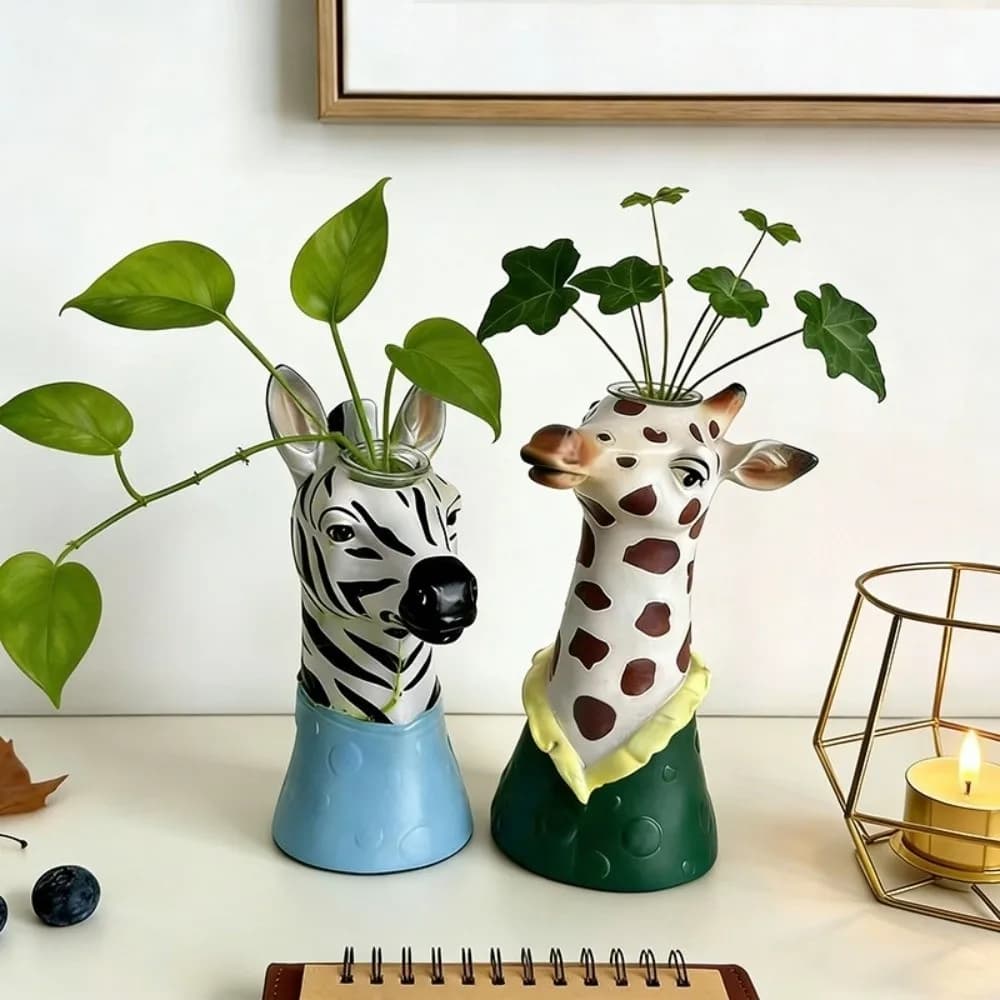 Vasos decorativos infantis em formato de girafa marrom e branco e zebra preto e branco com plantas verdes