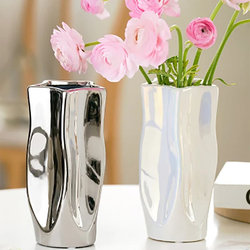 Jogo com 2 vasos decorativos Jácotei luxo prata galvanizada com design ondulado e flores rosas em ambiente