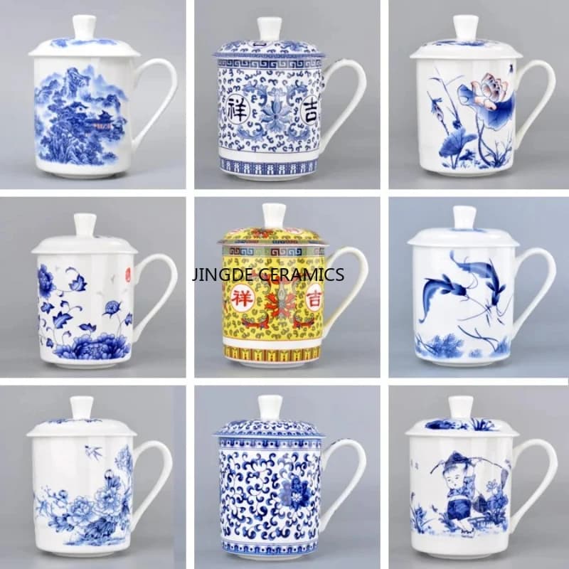 Caneca de porcelana azul e branca com tampa e alça, decorada com flores e paisagens. Fundo cinza. A marca 'JINGDE CERAMICS' está visível na parte inferior da imagem.
