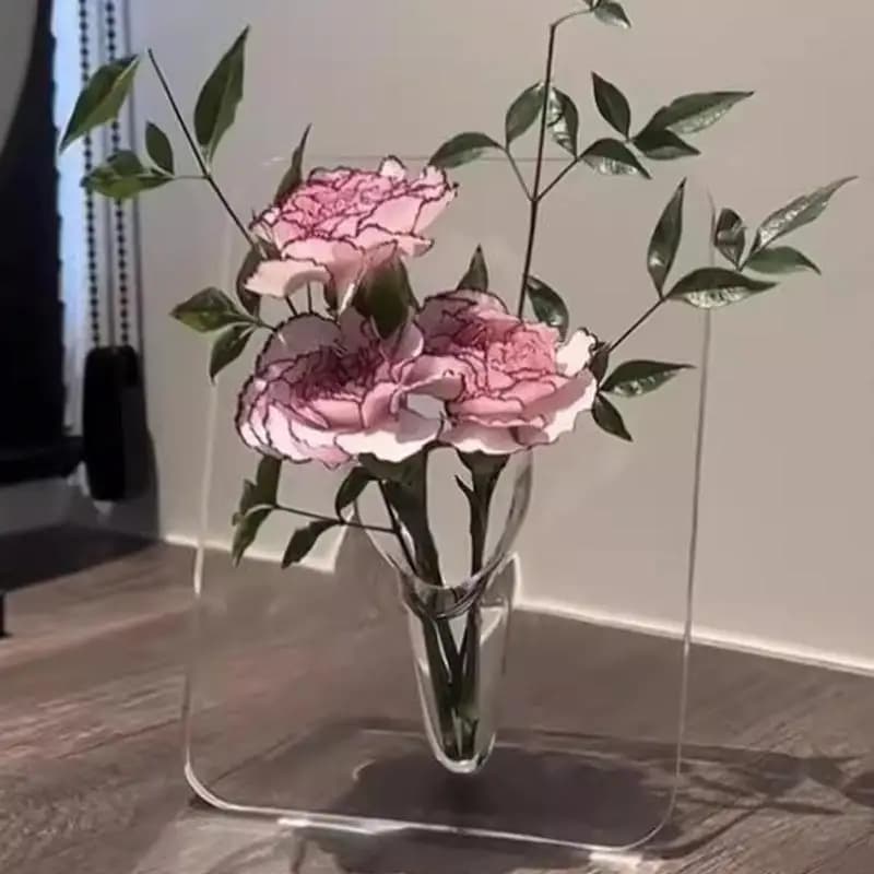 Vaso decorativo acrílico transparente com design moderno exibindo flores rosa e folhas verdes