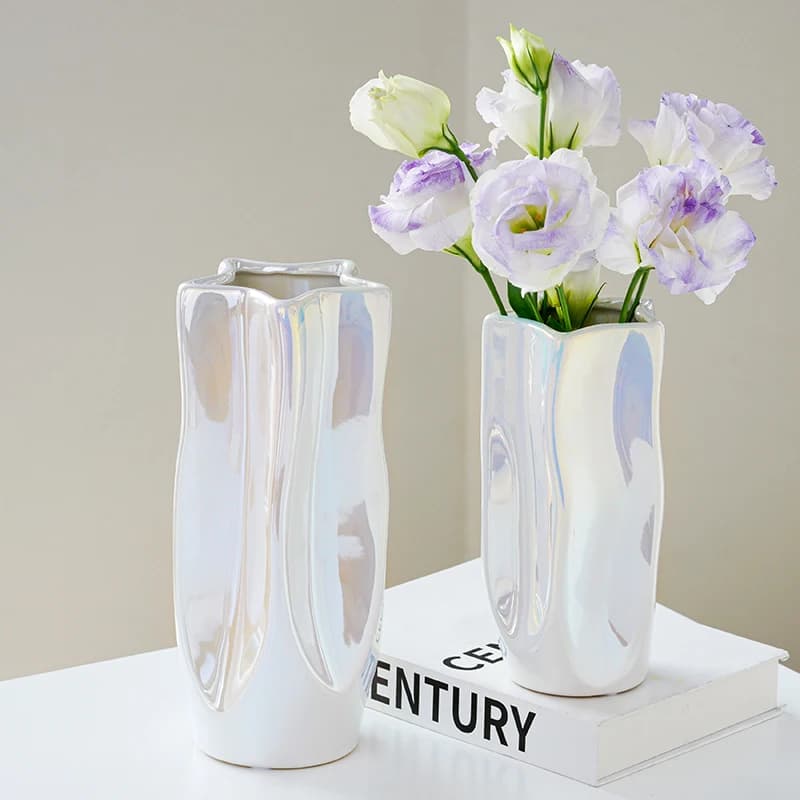Vasos decorativos Jácotei luxo prata galvanizada com design ondulado irregulares e flores lilás sobre livro