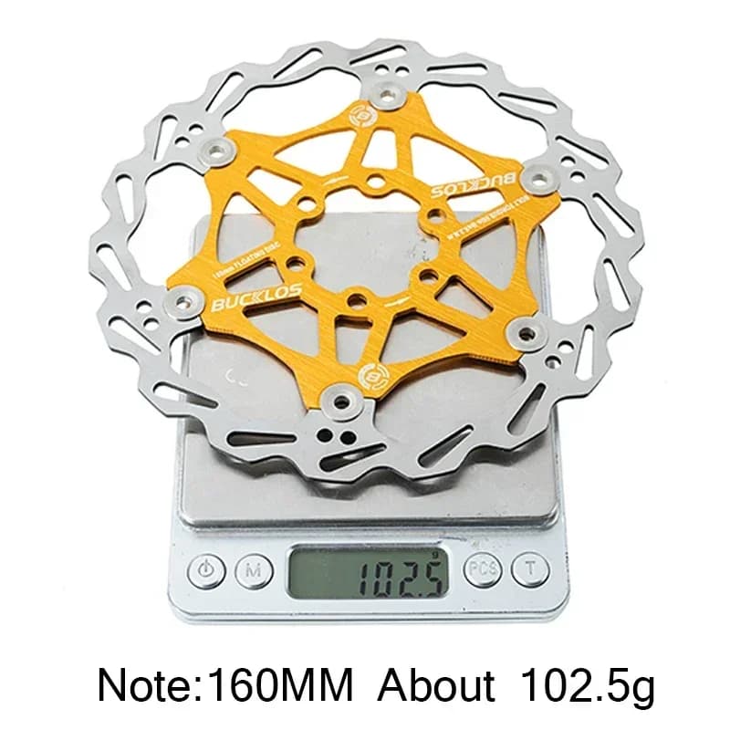 Rotor de freio Bucklos 160mm dourado e prata pesando 102,5g em balança digital