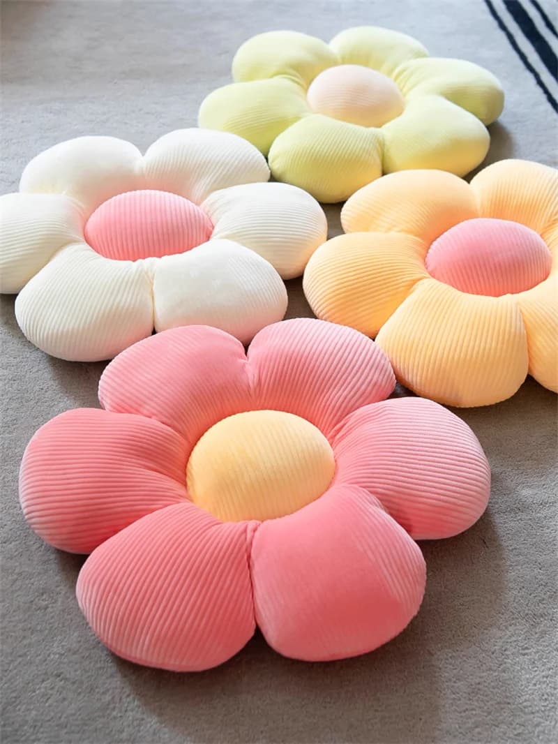 Almofadas de flor de pelúcia em cores pastel, rosa, amarelo, verde e branco.
