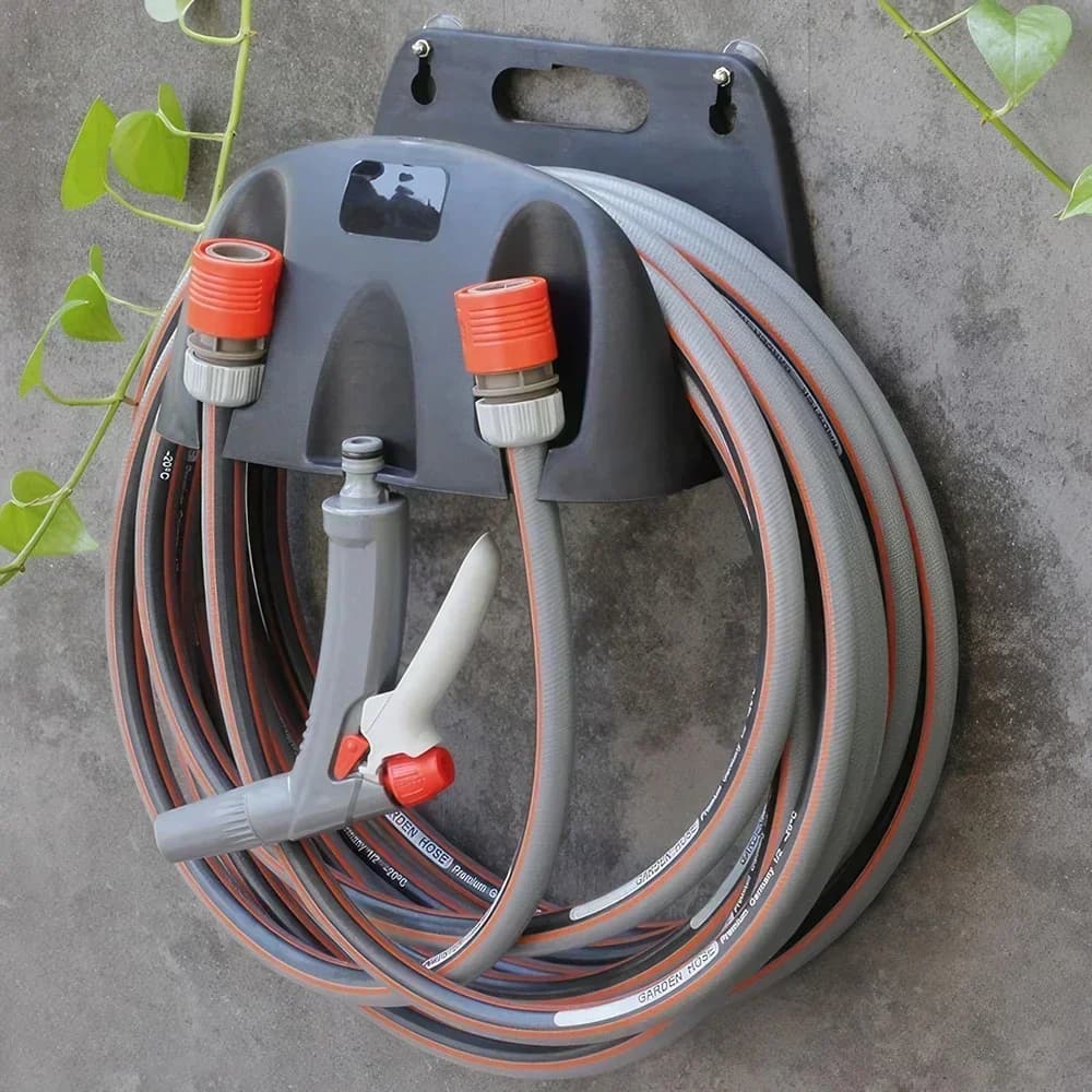 Suporte de mangueira de jardim montado na parede com mangueiras enroladas e conectores vermelhos