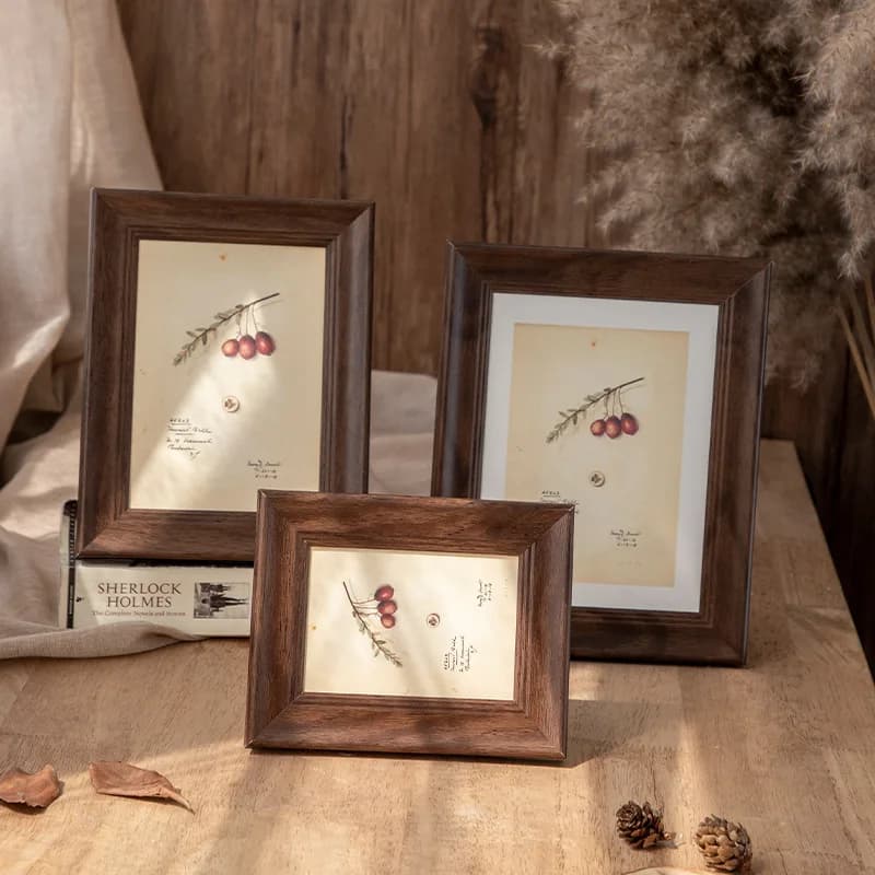 Três quadros decorativos de madeira com molduras simples, ilustrações de frutos vermelhos, fundo de madeira escura.
