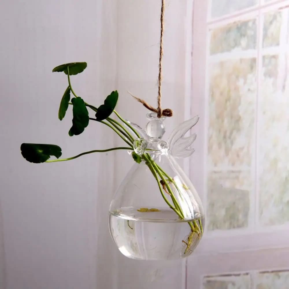 Vaso anjo pendurado de vidro transparente com planta hidropônica em ambiente iluminado