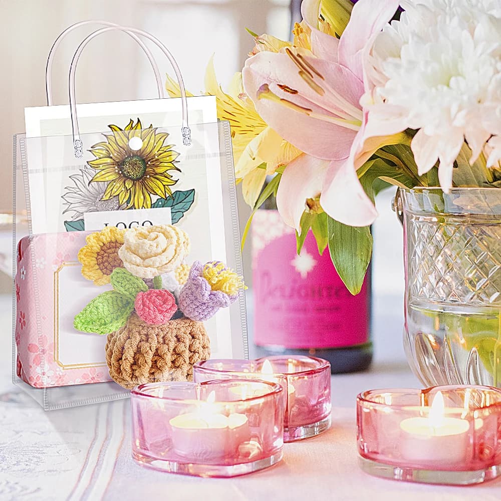Saco de presente transparente cristal com alça metálica exibido com flores e velas decorativas