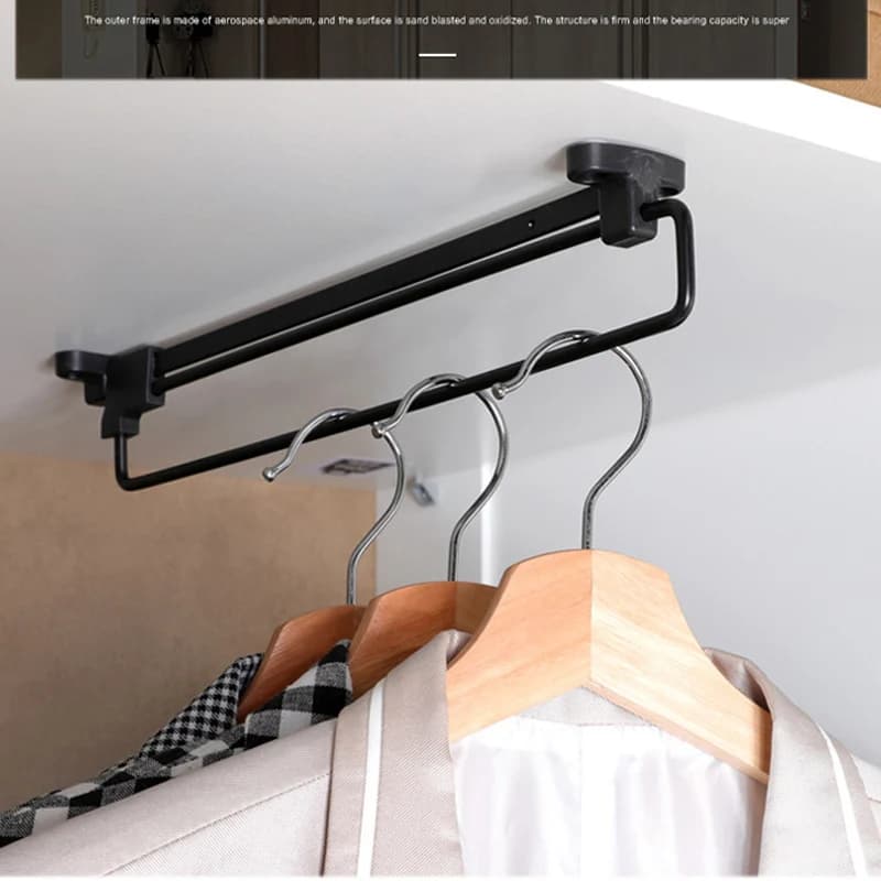 Organizador de guarda-roupa retrátil preto instalado com cabides e roupas penduradas
