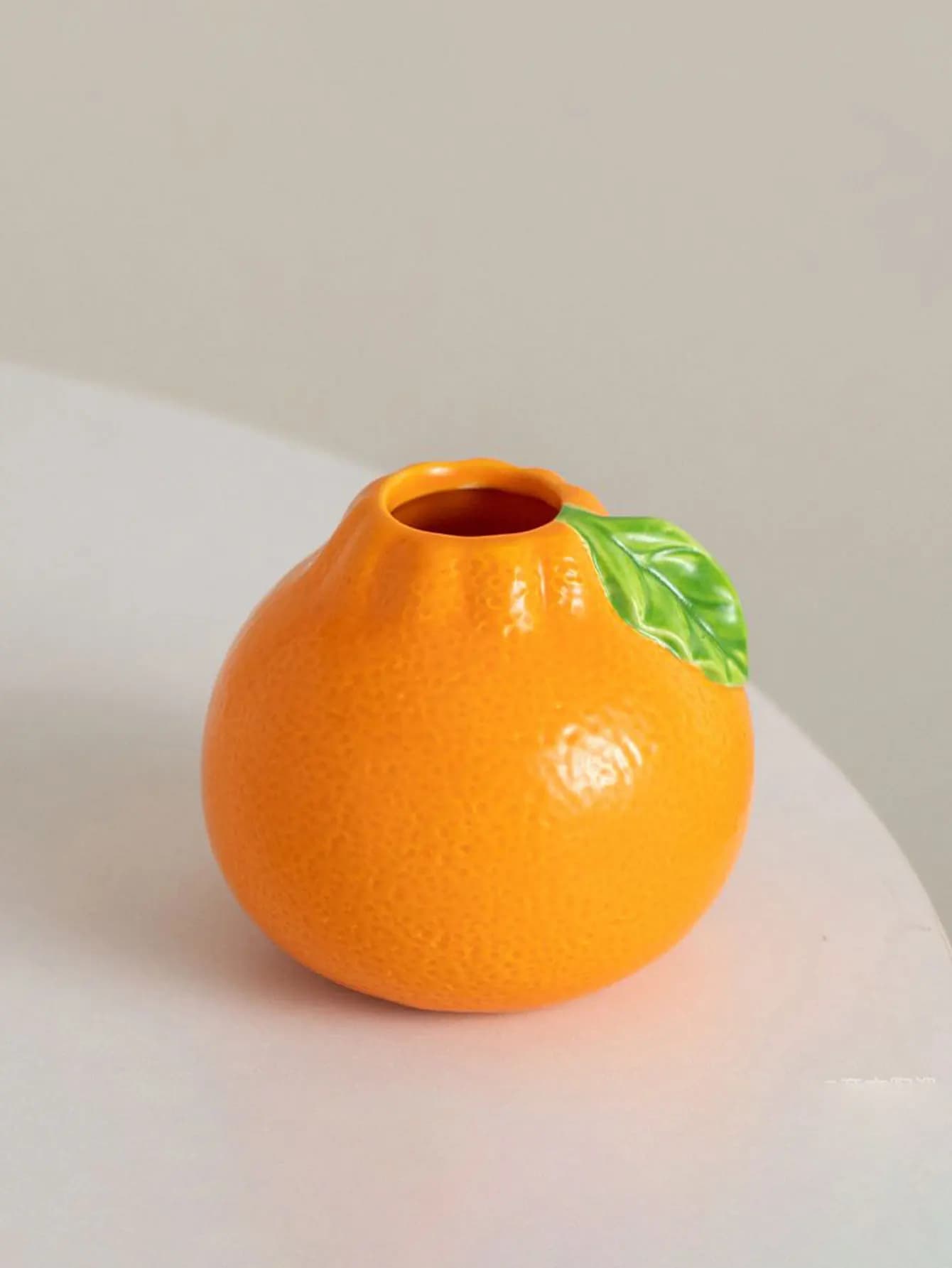 Vaso decorativo em cerâmica laranja com textura realista e folha verde, formato fruta criativa