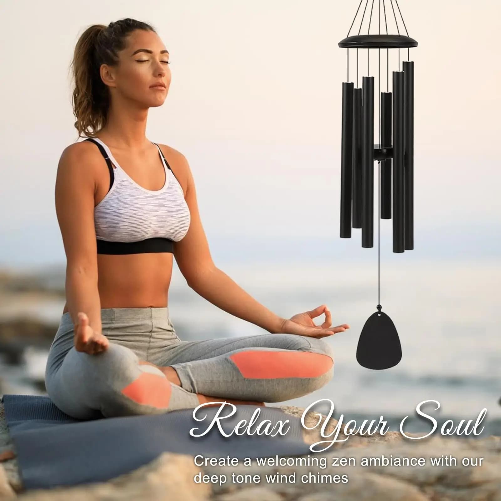 Mulher meditando ao ar livre com sino de vento preto decorativo 26 polegadas ao lado para relaxamento