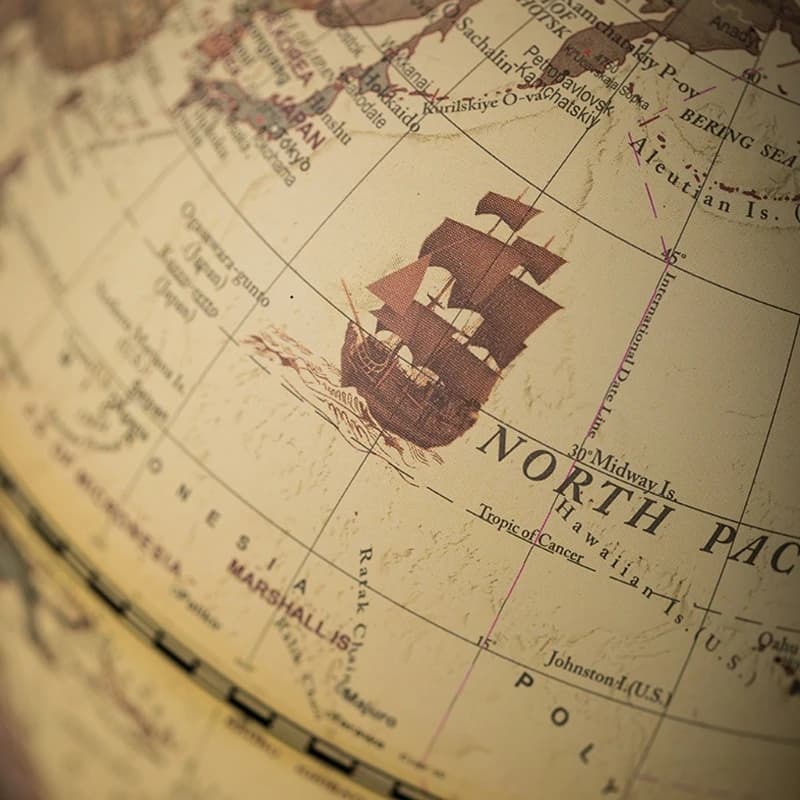 Globo terrestre decorativo vintage com mapa mundi e ilustração de navio antigo em tom marrom