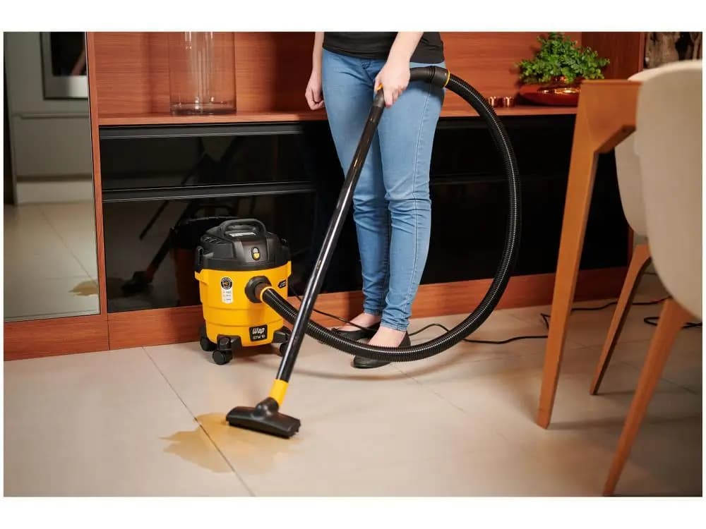 Aspirador WAP GTW 10 amarelo e preto aspirando líquido em piso cerâmico