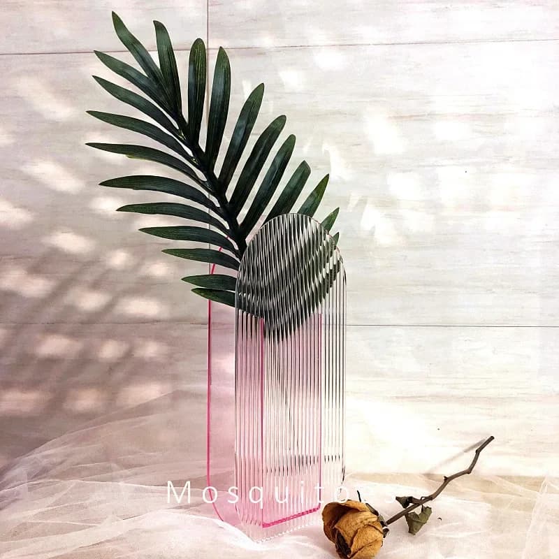 Vaso acrílico rosa transparente com design moderno e textura listrada vertical decorado com folhagem verde
