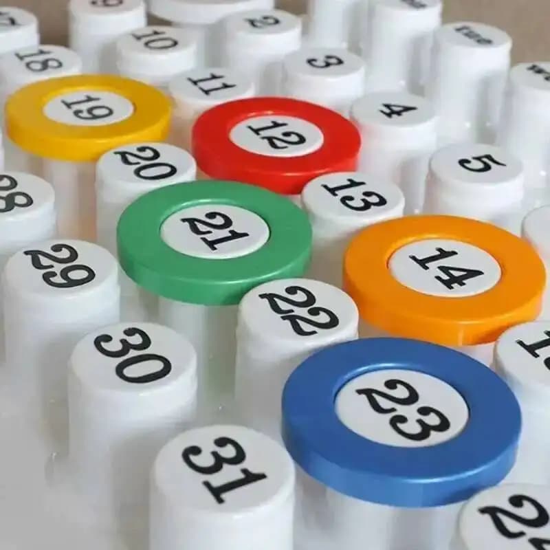 Calendário de mesa perpétuo com botões brancos e anéis coloridos em amarelo, vermelho, verde, azul e laranja