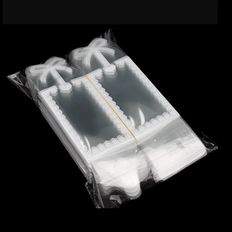 Pacote com caixas para lembrancinhas transparentes em PVC com desenho branco de laço e bordas decorativas