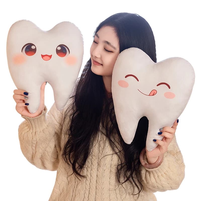 Brinquedo de pelúcia em forma de dente branco com olhos e boca sorridentes