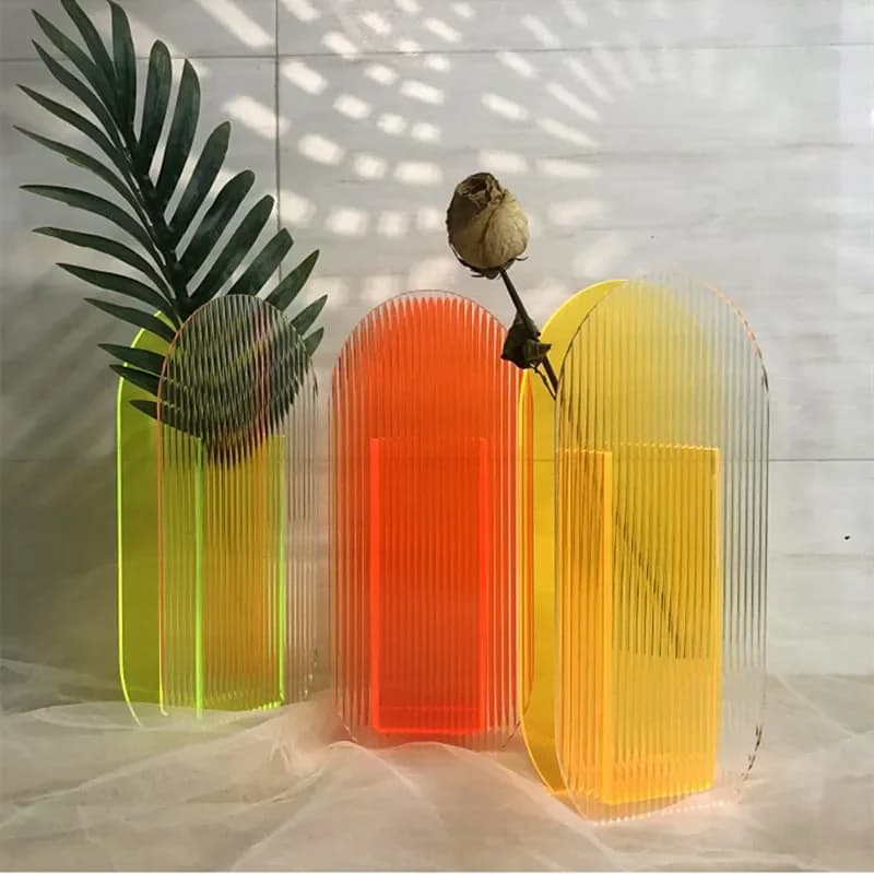 Vasos de acrílico coloridos com plantas e flores dentro