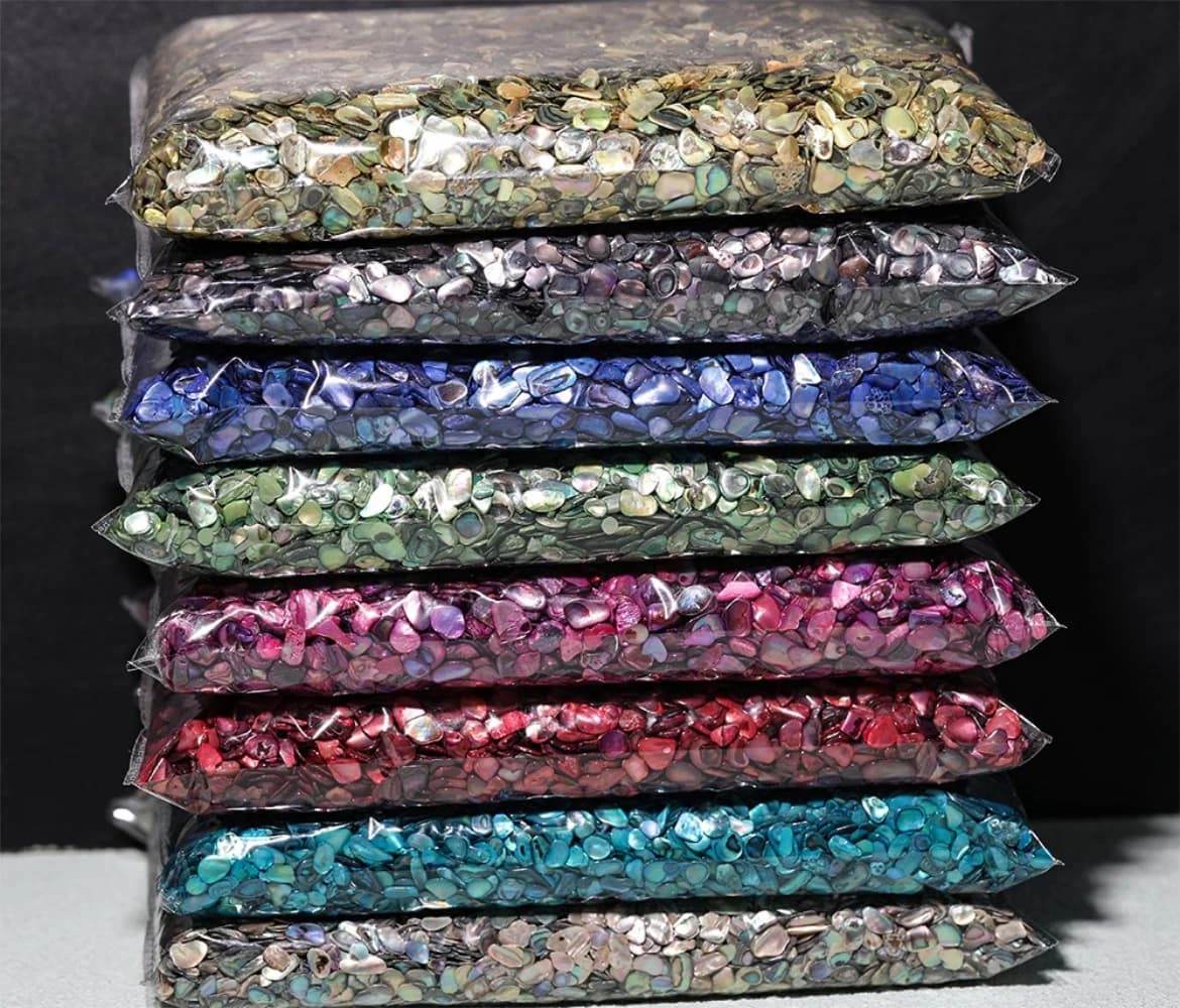 Pacotes empilhados de fragmentos de concha natural para nail art em várias cores vibrantes