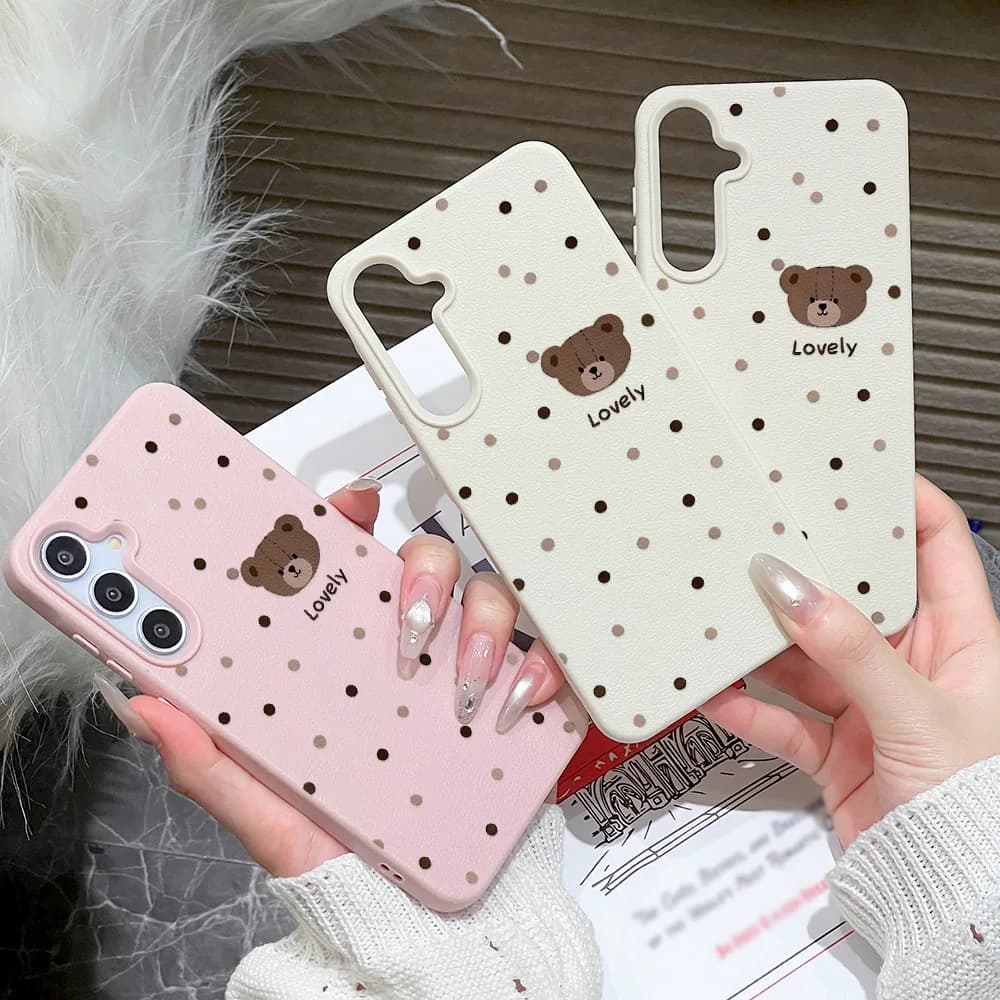 Capa de celular rosa, branca e preta com estampa de ursinho e pontos