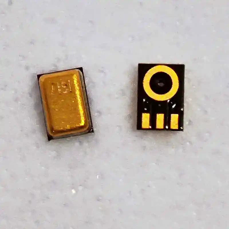 Peças de circuito impresso, uma dourada e outra preta com círculo amarelo e linhas amarelas