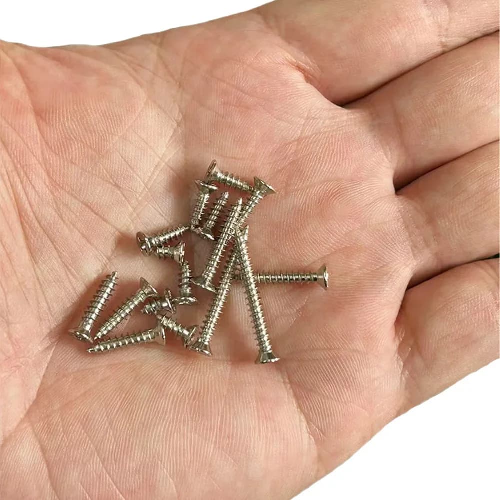 Parafusos autoatarraxantes miniatura em aço inoxidável cor prata na palma da mão