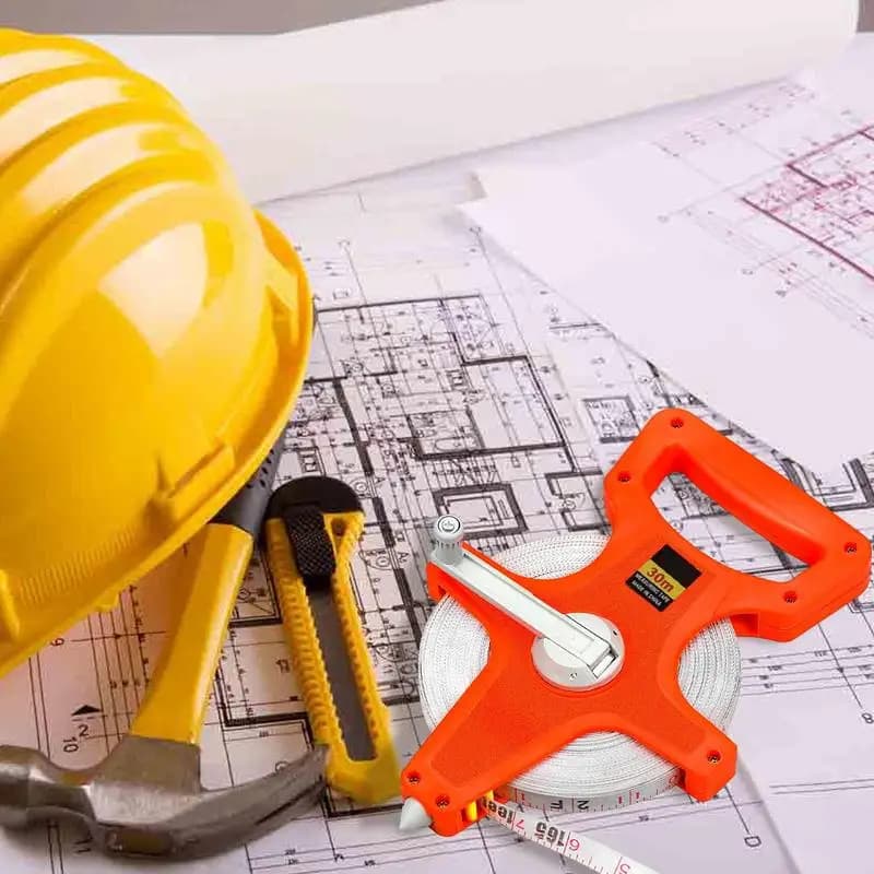 Fita métrica com carretel laranja de fibra de vidro 20m sobre planta arquitetônica com capacete e ferramentas
