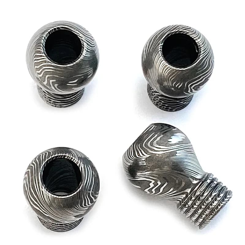 Pingente EDC aço padrão Damasco cinza, conjunto 3 peças, vista superior mostrando interior oco e textura detalhada