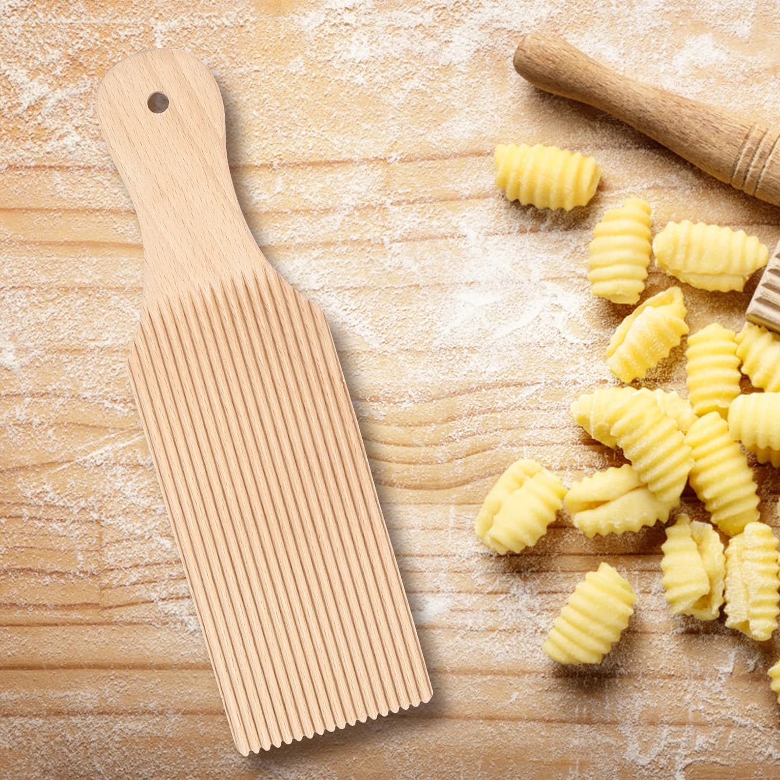 Placa de madeira clara para gnocchi caseiro ondulada com massa de gnocchi fresca sobre superfície de madeira com farinha
