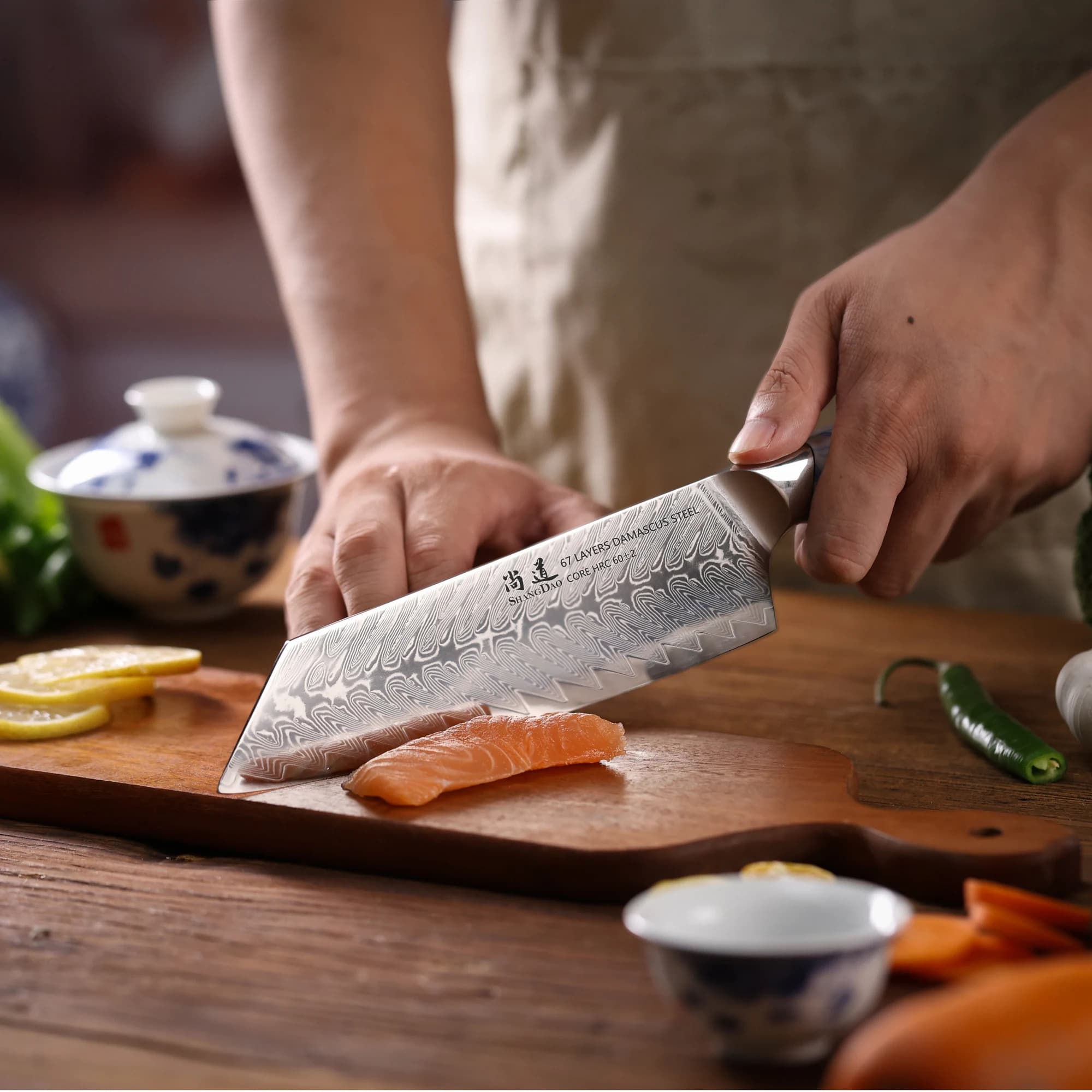 Faca Kiritsuke SHANGDAO cortando salmão com lâmina em aço damasco VG10 e cabo azul e branco