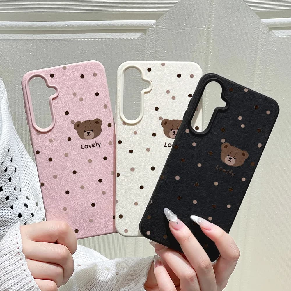 Capa de celular rosa, branca e preta com estampa de ursinho e pontos