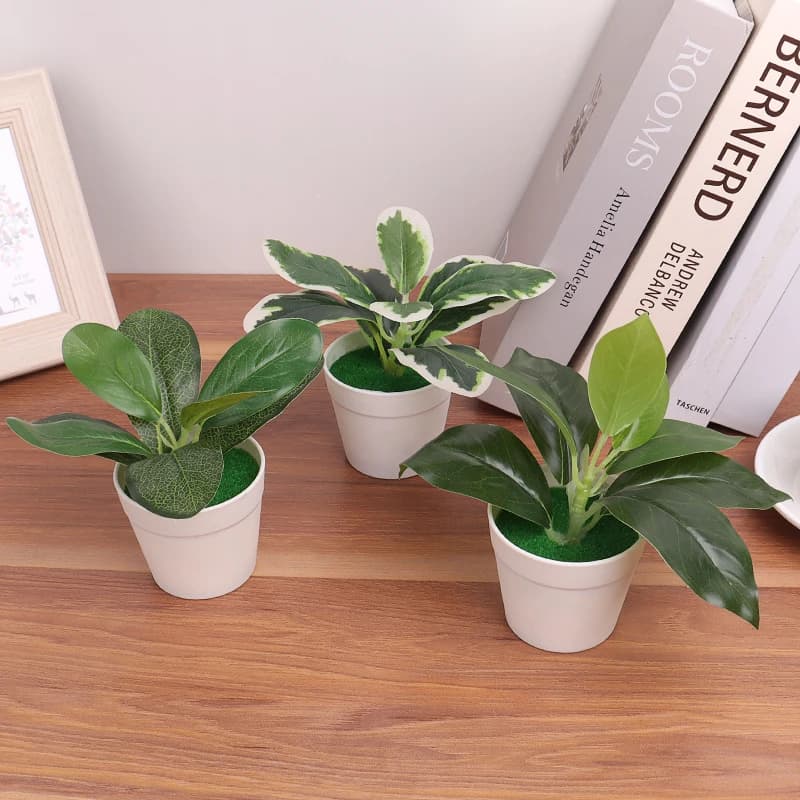 Trio de plantas artificiais decorativas mini linha bonsai em vasos plásticos brancos sobre mesa de madeira
